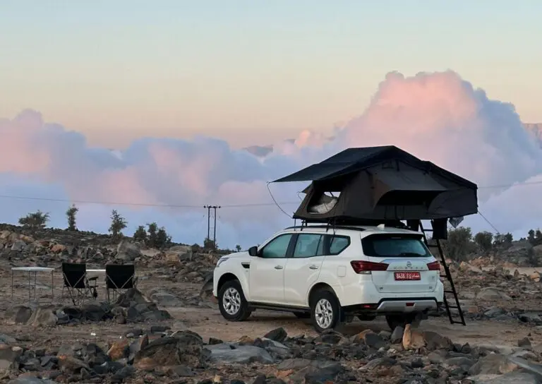 4x4 with a rooftop tent in the mountains above the clouds