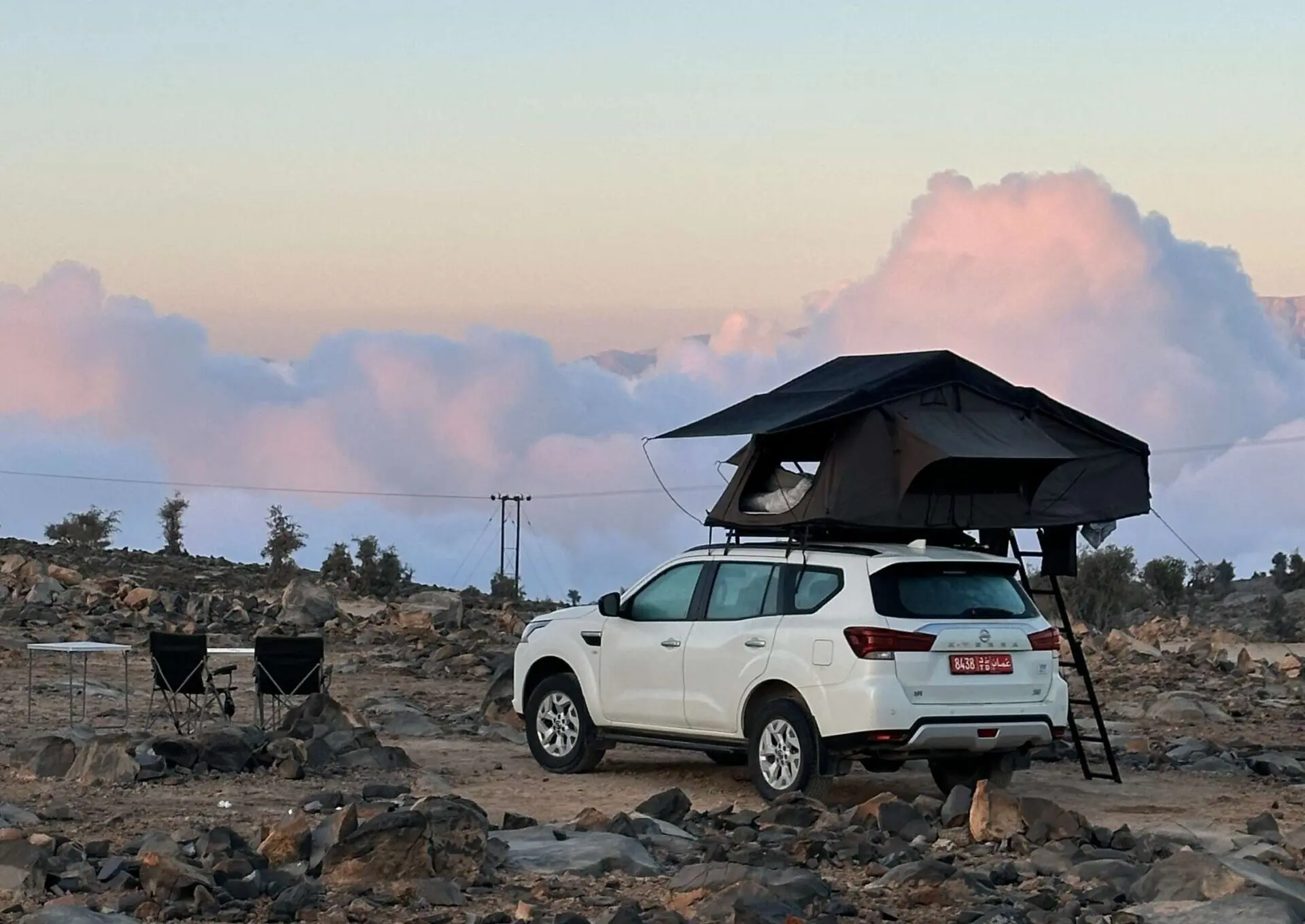 4x4 with a rooftop tent in the mountains above the clouds