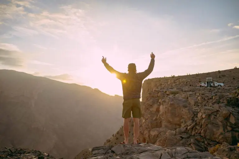 A man standing in front of a canyon in Oman.