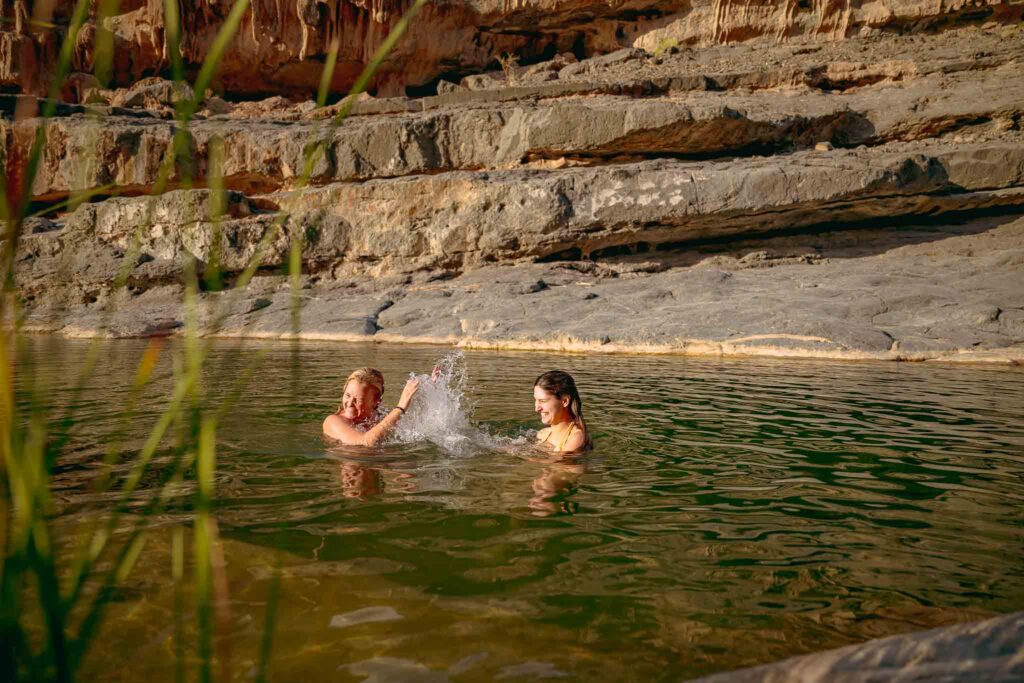 two people diving into a wadi in Oman