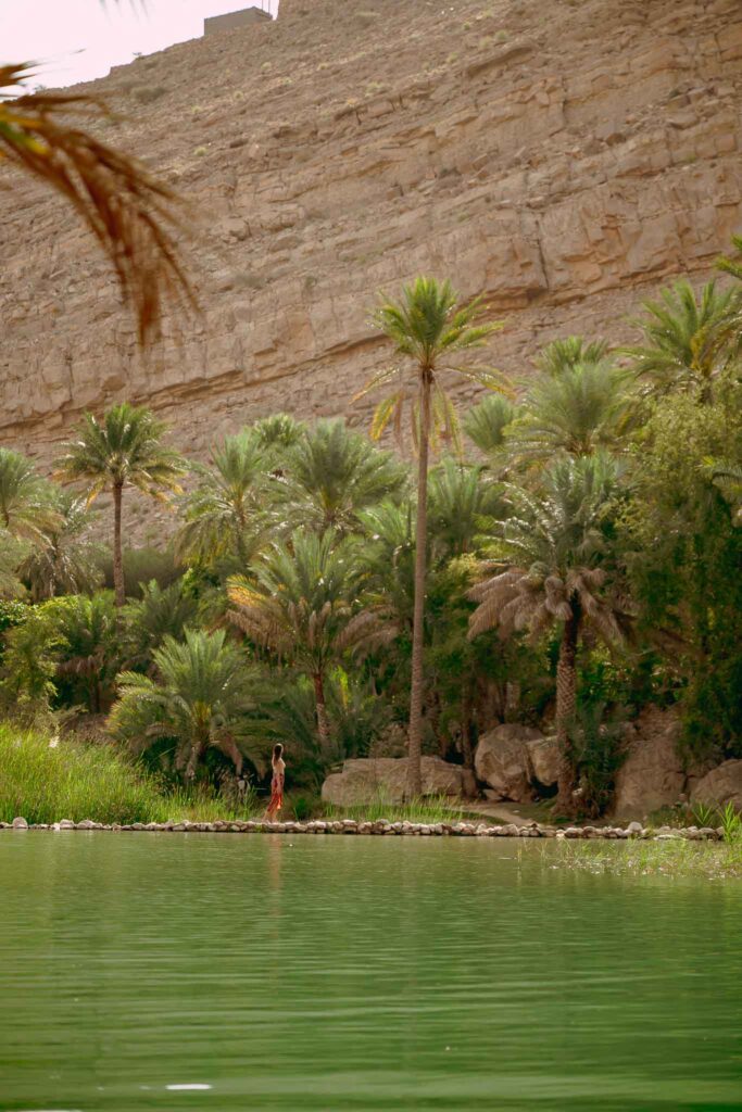 A woman walking along the water in Oman.