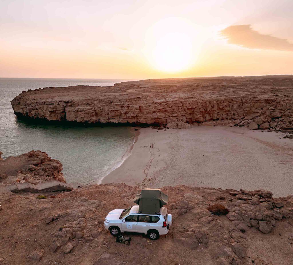 4x4 on top of a cove facing the ocean and the beach in Oman